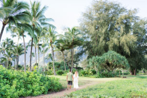 Kauai engagement photo shoot couple walking Hanalei Bay palm trees