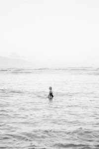 film photo of surfer girl sitting in ocean on surfboard